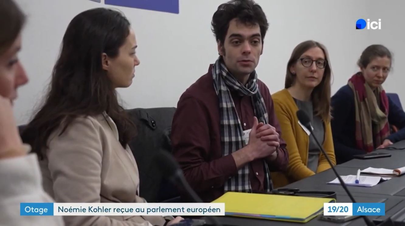 Capture du journal télévisé 19/20 Alsace, un bandeau indique 'Otage. Noémie Kohler reçue au parlement européen'. On y voit Tristan s'adressant à Chloé Ridel